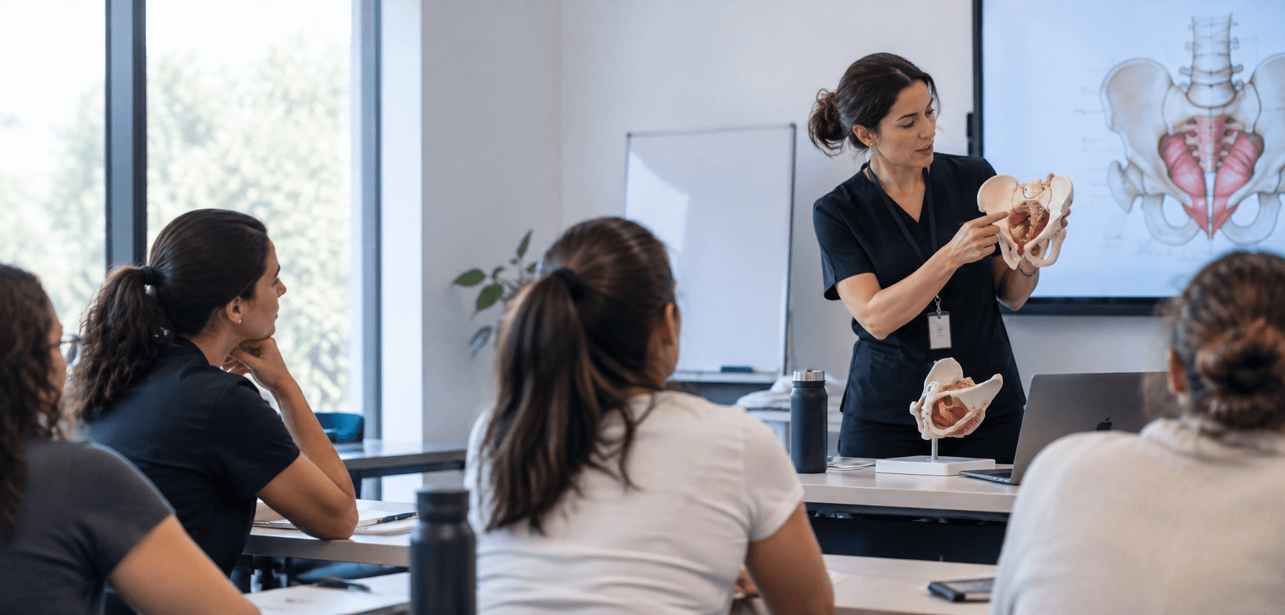 Una docente explica la anatomía pélvica en clase